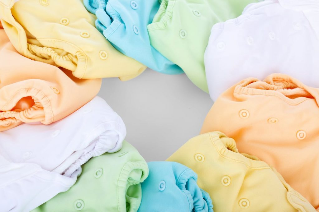 A top-view of colorful cloth diapers arranged in a circular pattern showcasing vivid hues and comfort.